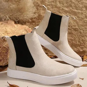 Vista lateral de botines Chelsea beige con elástico negro y suela gruesa blanca