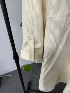 Close-up detail of the sleeve cuff and button on yellow striped seersucker shirt