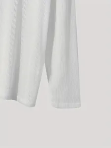 Detailed close-up of white ribbed long-sleeved top showing fabric texture and seams