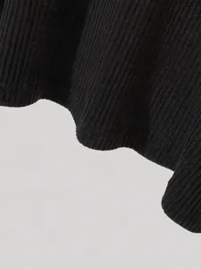 Close-up detail of the hem and black ribbed fabric texture of the casual long-sleeved top.