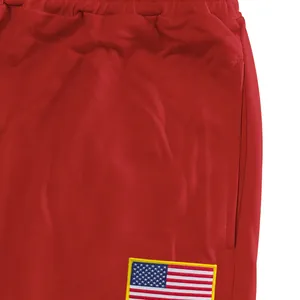 Gros plan d'un pantalon de sport rouge avec un écusson du drapeau américain