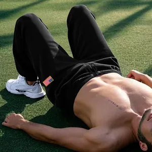 Détail de jogging de sport noir pour homme avec écusson drapeau américain sur herbe