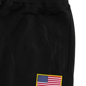 Gros plan sur le patch brodé du drapeau américain sur ce pantalon de sport noir