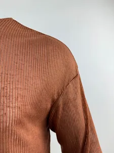 Close-up of brown ribbed fabric and drop shoulder seam on long sleeve top