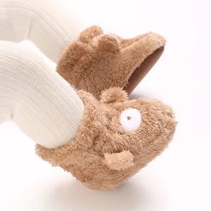 Detalle de botines de invierno para bebé en felpa marrón con diseño de ovejita