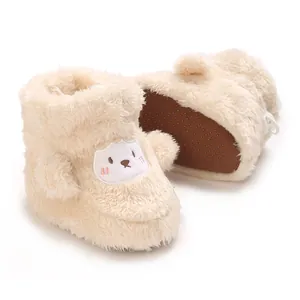 Primer plano de suaves botas de bebé color crema con lindo bordado de oveja
