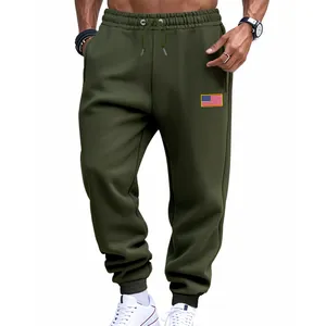 Détail d'un jogging pour homme vert olive avec un patch drapeau américain et taille à cordon