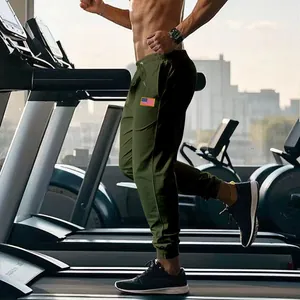 Détail d'un pantalon de jogging vert olive pour homme sur tapis roulant