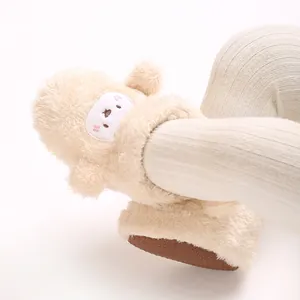 Vista detallada de una suave bota de peluche para bebé con cara de oveja bordada
