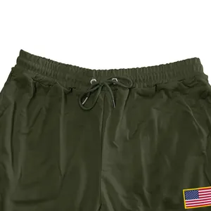 Détail d'un pantalon de jogging vert olive pour homme avec cordon et drapeau US
