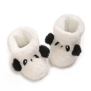 Detalle de botas de peluche de panda para bebé con suave forro polar y orejas.