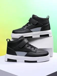 Gros plan montrant la texture et le design des baskets montantes noires pour garçons