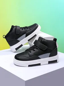 Détail de baskets montantes noires pour garçons avec semelles blanches et bride velcro