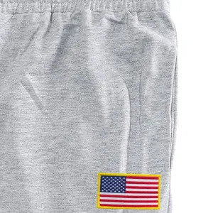 Gros plan d'un jogging gris pour hommes avec un écusson brodé du drapeau américain.