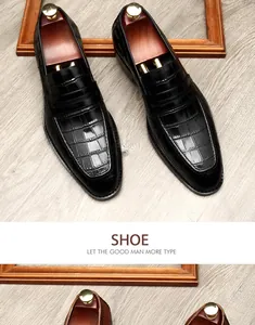 Detailopname van hoogwaardige zwarte leren herenloafers met chic krokodillenpatroon.