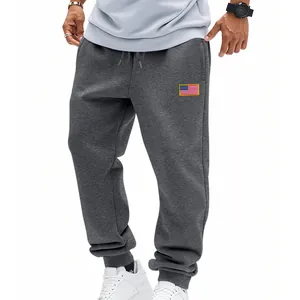 Vue détaillée d'un jogging gris foncé pour homme avec écusson drapeau US et poignets.