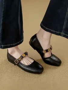 Elegant black leather Mary Jane flats with decorative gold floral buckle detail