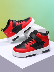 Gros plan sur les baskets montantes rouges et noires pour enfants avec bandes velcro.