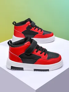 Vue détaillée de baskets montantes pour enfants rouges et noires sur un bloc de présentation blanc