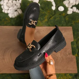 Mocasines negros elegantes con plataforma, una hebilla dorada y diseño en relieve