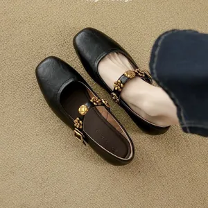 Elegant black Mary Jane flats with decorative gold flower buckles and square toe.