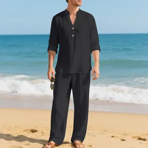 Completo in lino nero da uomo con camicia Henley e pantaloni ampi su una spiaggia