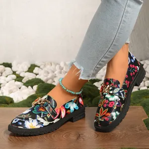 Vista detallada de mocasines florales para mujer con hebilla dorada y suela gruesa
