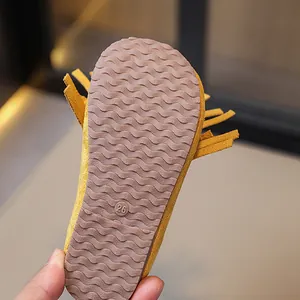 Close-up bottom view of kids yellow fringe Mary Jane shoes featuring wavy non-slip sole