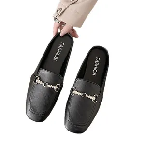 Zwarte mules met spitse neus, elegante metalen gesp en pareldetails