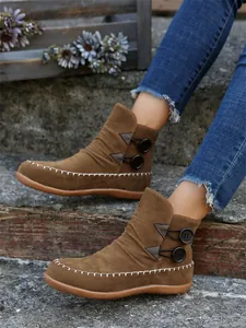 Women's brown suede flat ankle boots with decorative side buttons and stitching