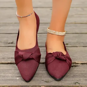 Dettaglio di eleganti ballerine in maglia bordeaux con un raffinato fiocco annodato.