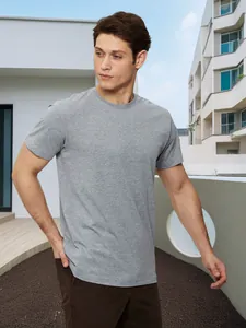Detailweergave van een klassiek grijs katoenen heren-T-shirt in een buitenomgeving.