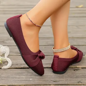 Vista dettagliata di ballerine in maglia bordeaux con fiocco indossate da una modella
