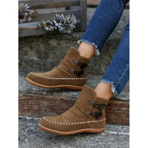 Women's brown suede flat ankle boots with contrast stitching and side buttons