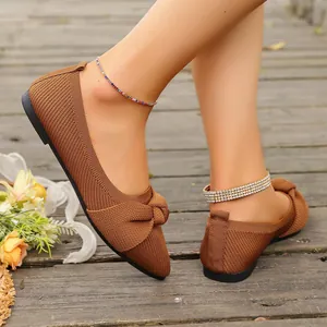 Dettaglio di ballerine a punta in maglia marrone con fiocco elegante su modella