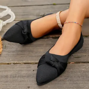 Dettaglio ravvicinato di ballerine in maglia nera a punta con fiocco elegante
