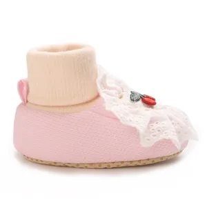 Detailed side view of pink princess baby sock shoes with white lace trim and cherry embroidery