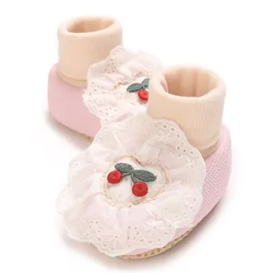 Macro view of pink newborn baby girl booties with cute cherry embroidery and lace detail