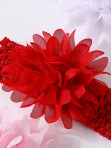 Detalle de cerca de una gran flor de gasa roja en una suave diadema de encaje para bebés