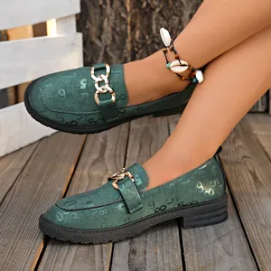 Detalle de mocasines con plataforma verdes para mujer con patrones numéricos y cadena dorada