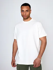Dettaglio di una t-shirt bianca da uomo a maniche corte con finitura in cotone pregiato.