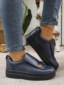 Close-up of stylish navy blue platform sneakers with elegant gold buckle decorative detail