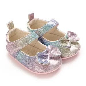 Gros plan de chaussures princesse bébé arc-en-ciel à paillettes avec nœud et semelle souple