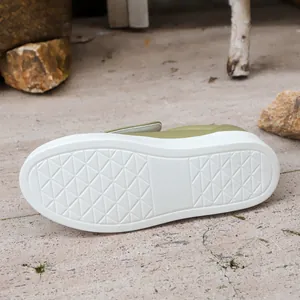 Detail view showing the thick white non-slip sole of the green casual platform sneaker.