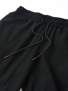 Detail des elastischen Bunds mit Kordelzug an einer schwarzen Baumwoll-Leinen-Sporthose.