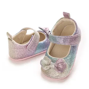 Gros plan de chaussures princesse bébé arc-en-ciel scintillantes avec nœud pailleté