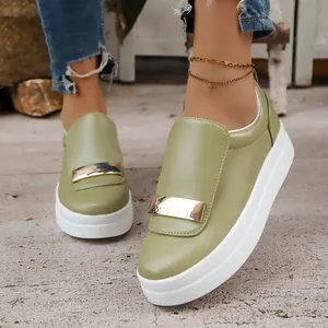 Detailed view of women's olive green platform loafers with gold metallic plate accent