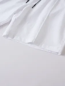Detailed macro view of white breathable linen fabric and textured drawstring on men's beach shorts
