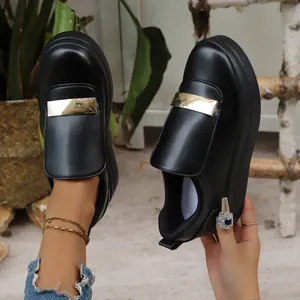 Detailed view of stylish black platform loafers with a decorative gold metallic bar.