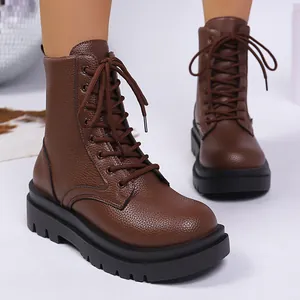 Detail shot of brown leather combat boots with thick soles and lace-up design